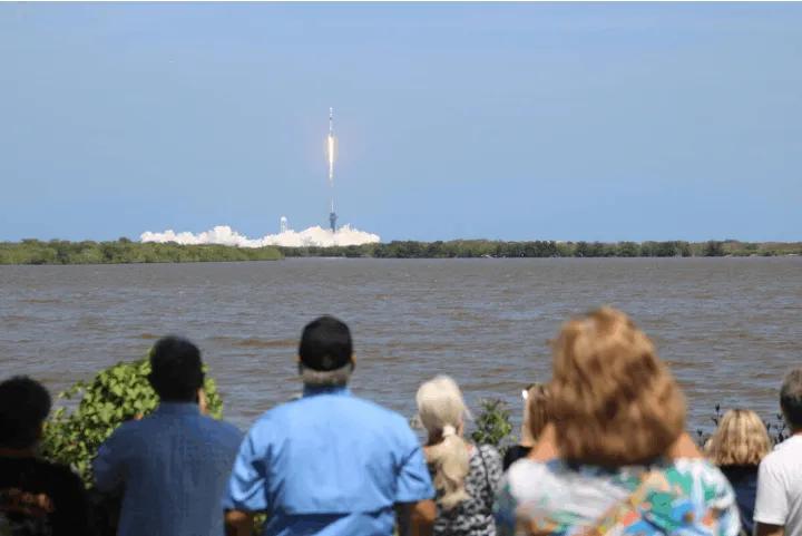 Spectators watching a rocket launch across the water from Banana Creek bleachers