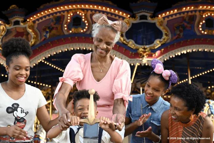 A family smiling as a young boy pulls the sword from the stone near Prince Charming Regal Carrousel