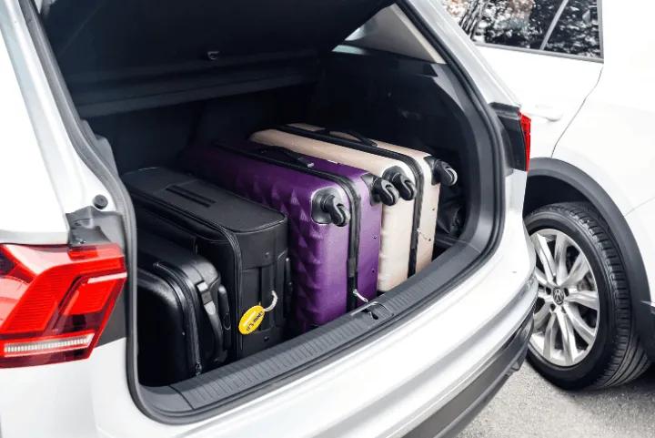 Multiple pieces of luggage packed neatly inside an open car boot