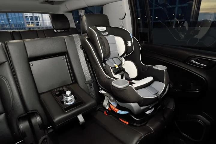 Child safety seat installed on the back seat of a vehicle