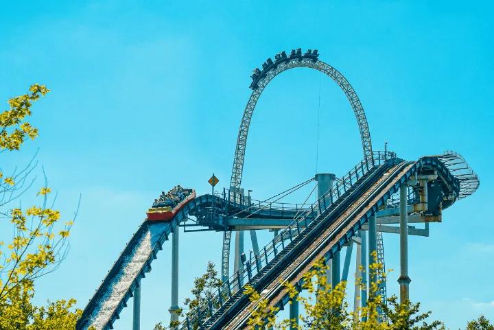Riders descending Tidal Wave's slope with Colossus's loop rising behind them at Thorpe Park