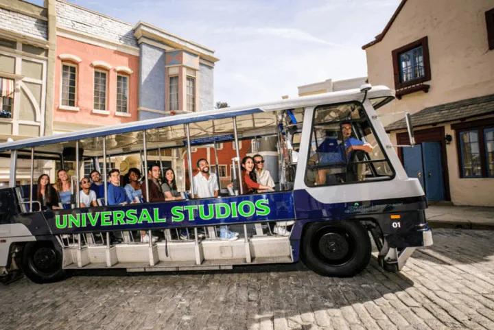 Guests riding the Universal Studios tram past studio backlot buildings