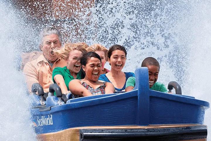 Riders drenched in a wave of splashback as their boat plunges through Journey to Atlantis at SeaWorld Orlando