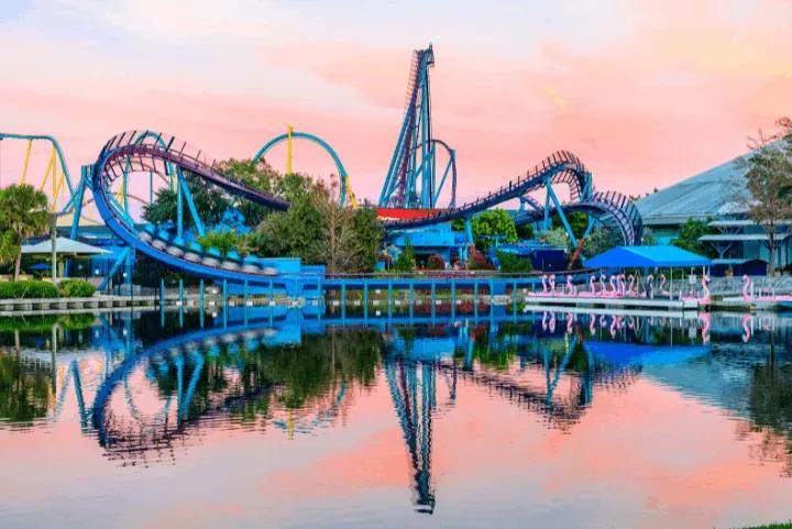 Mako roller coaster track reflected in the lagoon at SeaWorld Orlando during golden-hour sunset