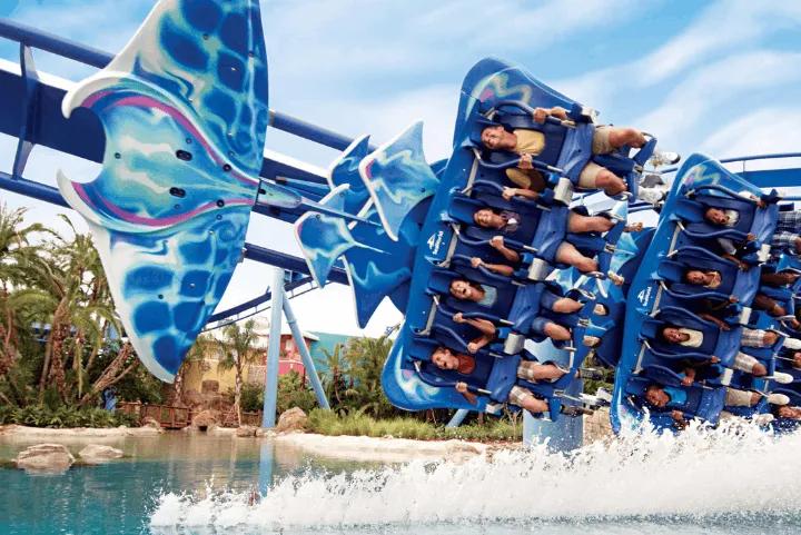 Manta flying roller coaster riders soaring face-down over the lagoon at SeaWorld Orlando