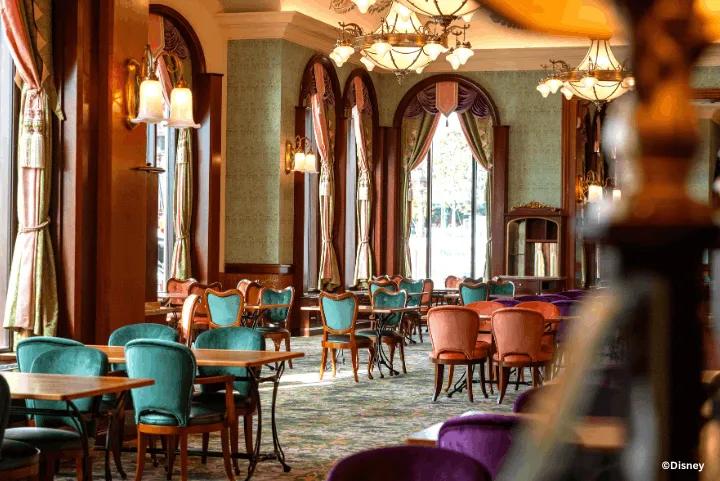 Elegant dining room inside The Regal View Restaurant & Lounge featuring ornate chandeliers, velvet chairs, and large arched windows