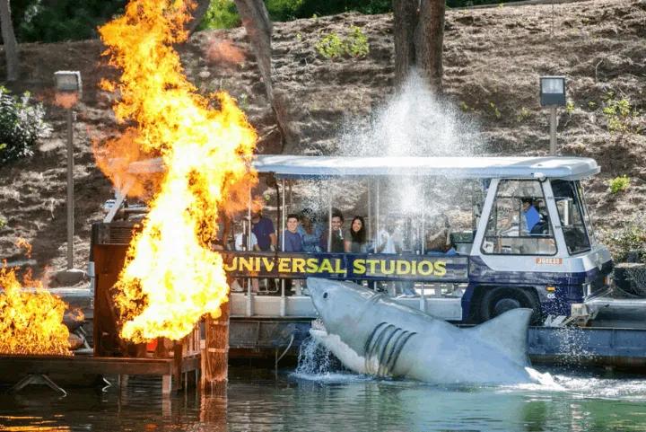 Studio tour tram passing a shark attack and fire effect on Amity Lake at Universal Studios Hollywood