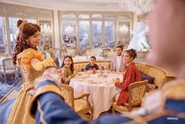 Princess Belle interacting with Guests during character dining inside a restaurant