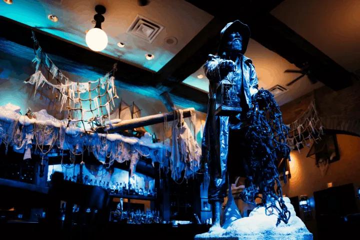 Frozen fisherman statue holding a lantern and net inside the ice-storm-themed Thirsty Fish bar at Loews Portofino Bay Hotel
