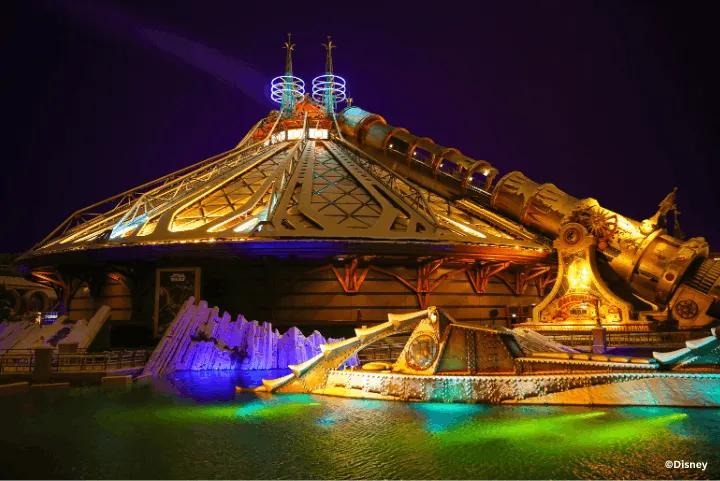 Nighttime view of the illuminated Hyperspace Mountain dome with the Columbiad cannon and Nautilus submarine in the foreground