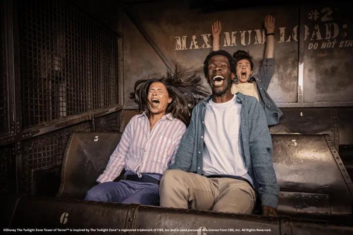 xcited guests shouting with their hands in the air inside the elevator vehicle of The Twilight Zone Tower of Terror