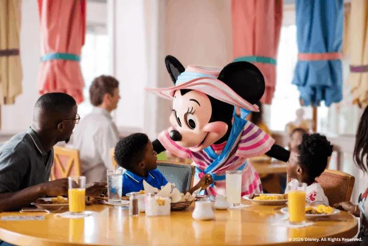 Minnie Mouse greeting a family during breakfast at Disney's Yacht Club Resort