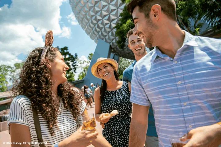 A group of friends enjoying food and drinks in front of Spaceship Earth at EPCOT
