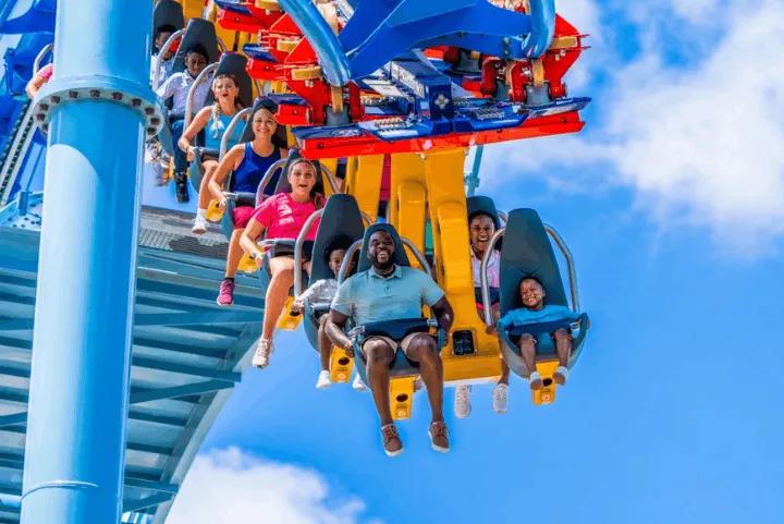 Guests enjoying a roller coaster ride under a clear blue sky