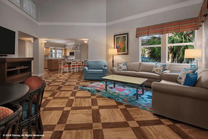 Spacious living room in a Three Bedroom Grand Villa at Disney's Old Key West Resort featuring patterned wood floors, plush seating, and vaulted ceilings