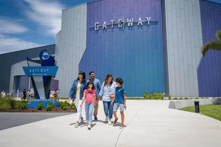 A family walking together outside the Gateway attraction at Kennedy Space Center