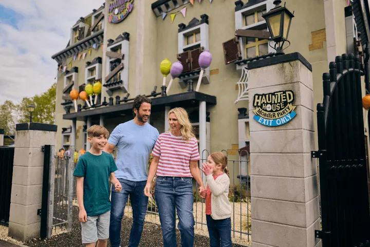 A family of four walking outside the Haunted House Monster Party attraction at Legoland Windsor