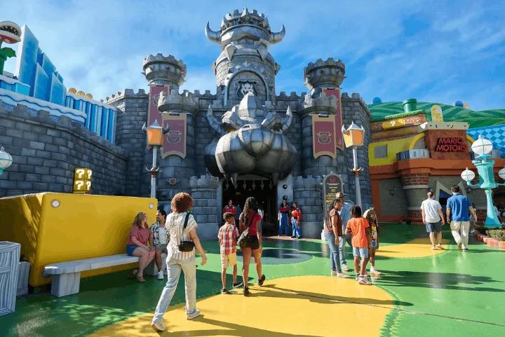 Guests walking outside Bowser's Castle at the entrance to Mario Kart: Bowser's Challenge in SUPER NINTENDO WORLD