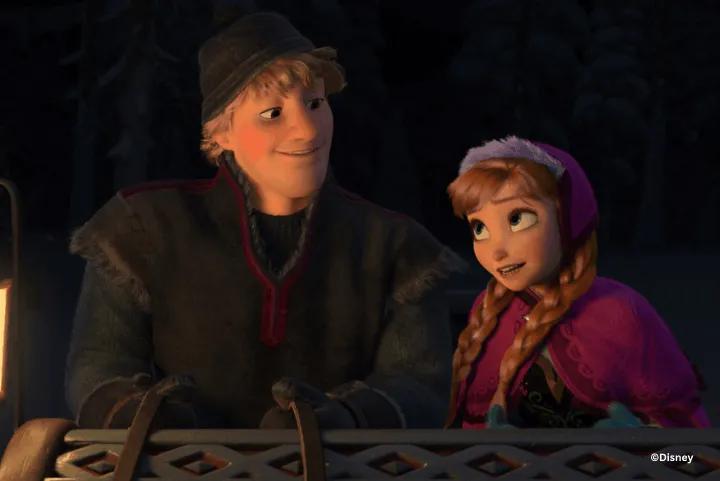Kristoff and Anna smiling at each other while riding in a sleigh at night, both wearing winter coats and hats