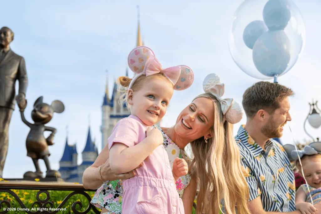 A mother and daughter wearing mouse ears smiling in front of Cinderella Castle.