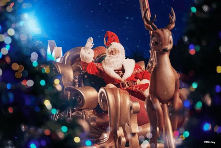 Santa Claus waving from his sleigh with a reindeer