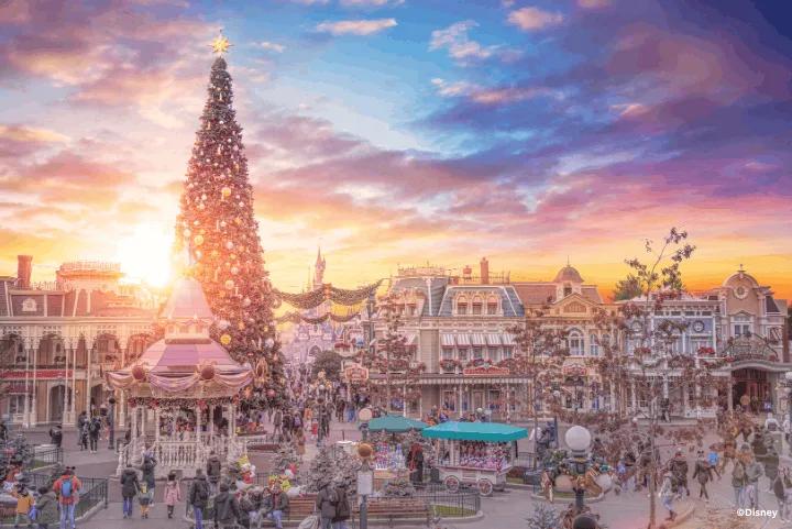 Main Street, U.S.A. decorated for the holidays with a giant Christmas tree, gazebo, and garlands at sunset