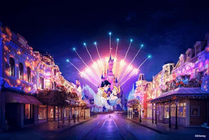 Sleeping Beauty Castle illuminated with colorful projections and fireworks during a nighttime show