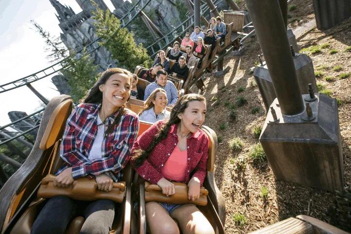 Guests smiling while riding the Flight of the Hippogriff roller coaster
