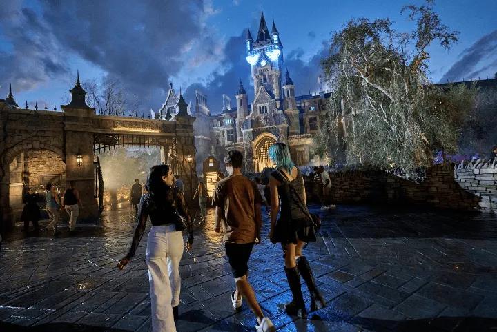 Guests walking toward a spooky, gothic-style castle at night