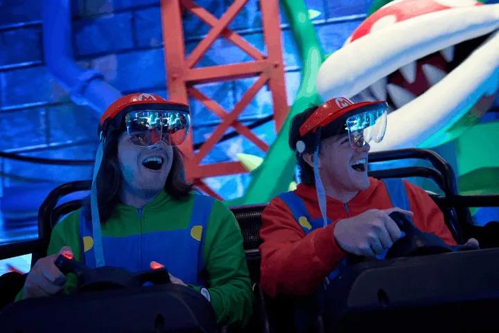 Two guests on a Mario-themed ride wearing AR visors