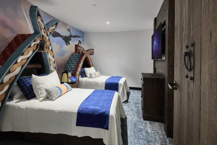 A children’s suite bedroom with Viking-style themed beds and colorful murals based on "How to Train Your Dragon"