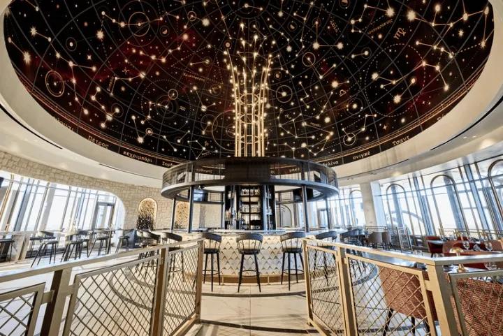 Indoor restaurant bar under an intricate domed ceiling decorated with celestial constellations and star patterns