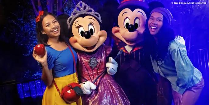 Mickey's Not-So-Scary Halloween Party Guests dressed as Snow White and one of the Seven Dwarfs meeting Mickey and Minnie in their Halloween costumes