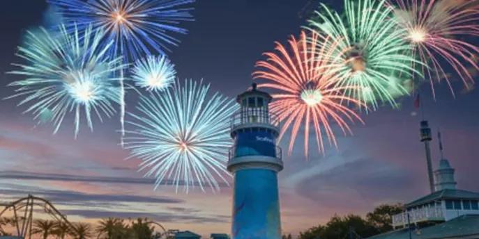 SeaWorld Summer Spectacular Multi-coloured fireworks being set off above a lighthouse as the sun is setting