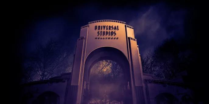 A large archway reading Universal Studios Hollywood surrounded by fog at night