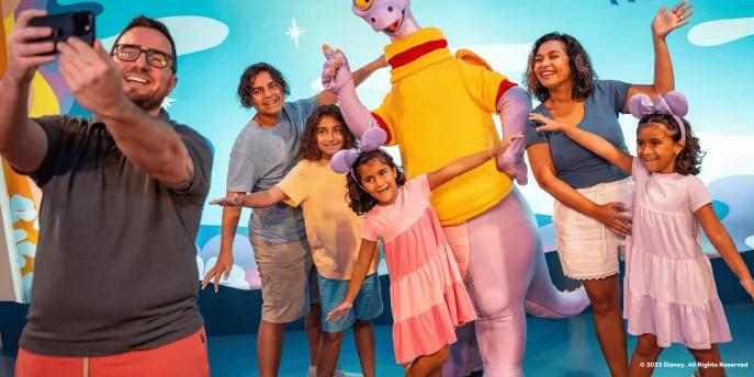 Figment Meet and Greet A family posing with a large purple dragon while taking a selfie