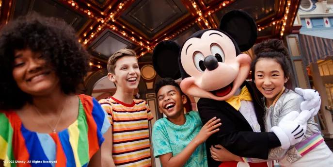 Walt Disney World Resort in Florida Mickey Mouse hugging and posing with 4 young adults