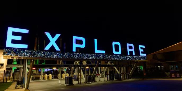 Holidays in Space at Kennedy Space Center An entrance gate decorated with Christmas decorations and "EXPLORE" lit up with blue lights