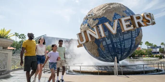 A family walking in front of the Universal globe at Universal Orlando Resort