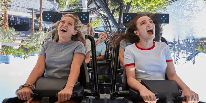 Jurassic World VelociCoaster Two young women with open mouths on an inversion on VelociCoaster
