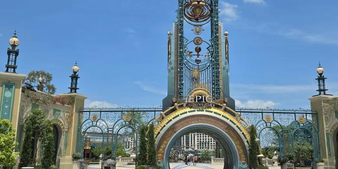 Universal Epic Universe Grand entrance with a semicircle portal opening and above there's a statue of a planet and star constellation.