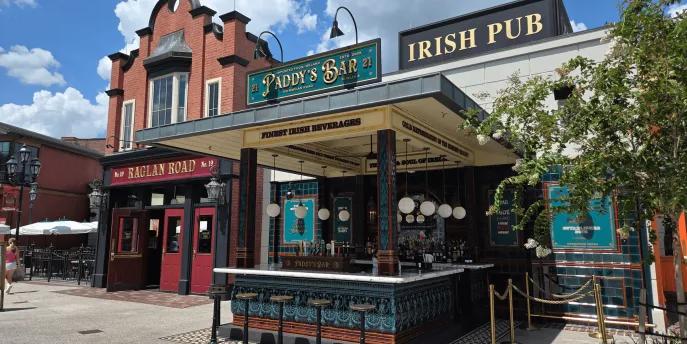 Raglan Road at Disney Springs An irish pub with a sign saying Raglan Road Irish Pub, there is a bar and multiple bar stools.