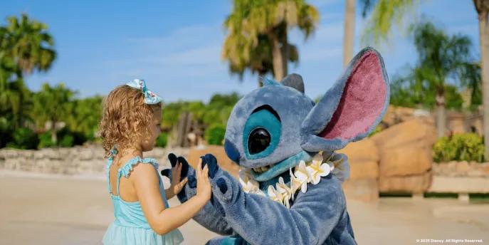 An adorable character meet-and-greet at a sunny Walt Disney World location, showing a young child playing with Stitch on the beach, a great example of fun outside the main theme parks for young families.