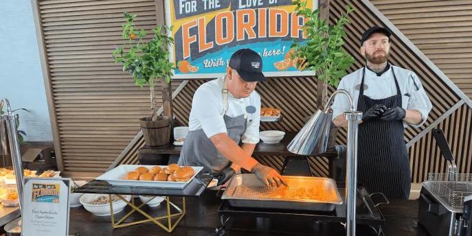 Buffet style food served by a chef in clean, modern restaurant with another chef stood behind.