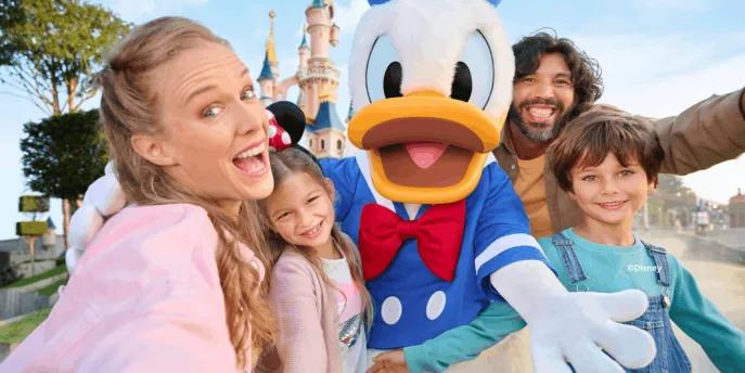A happy family meeting Donald Duck at Disneyland Paris with the iconic castle in the background.