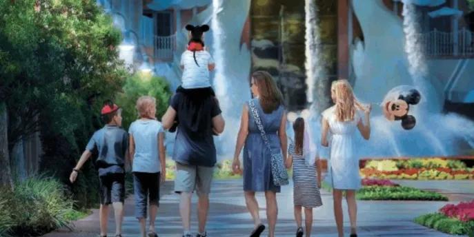 A family walking toward the Swan and Dolphin Resort fountains at Walt Disney World.