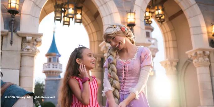 A young girl meeting Rapunzel in front of the castle at Disney World