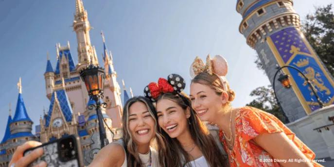 Three guests taking a selfie outside Cinderella Castle