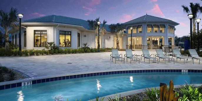Lazy river and clubhouse with lounge chairs at Storey Lake Resort during dusk