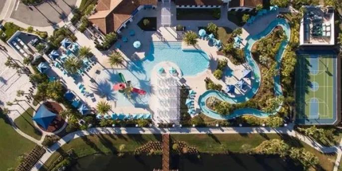 Aerial view of the resort pool complex, lazy river, and sports courts at Windsor at Westside